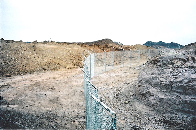 At closure, a chain link fence with dirt berm was placed around the open pit workings